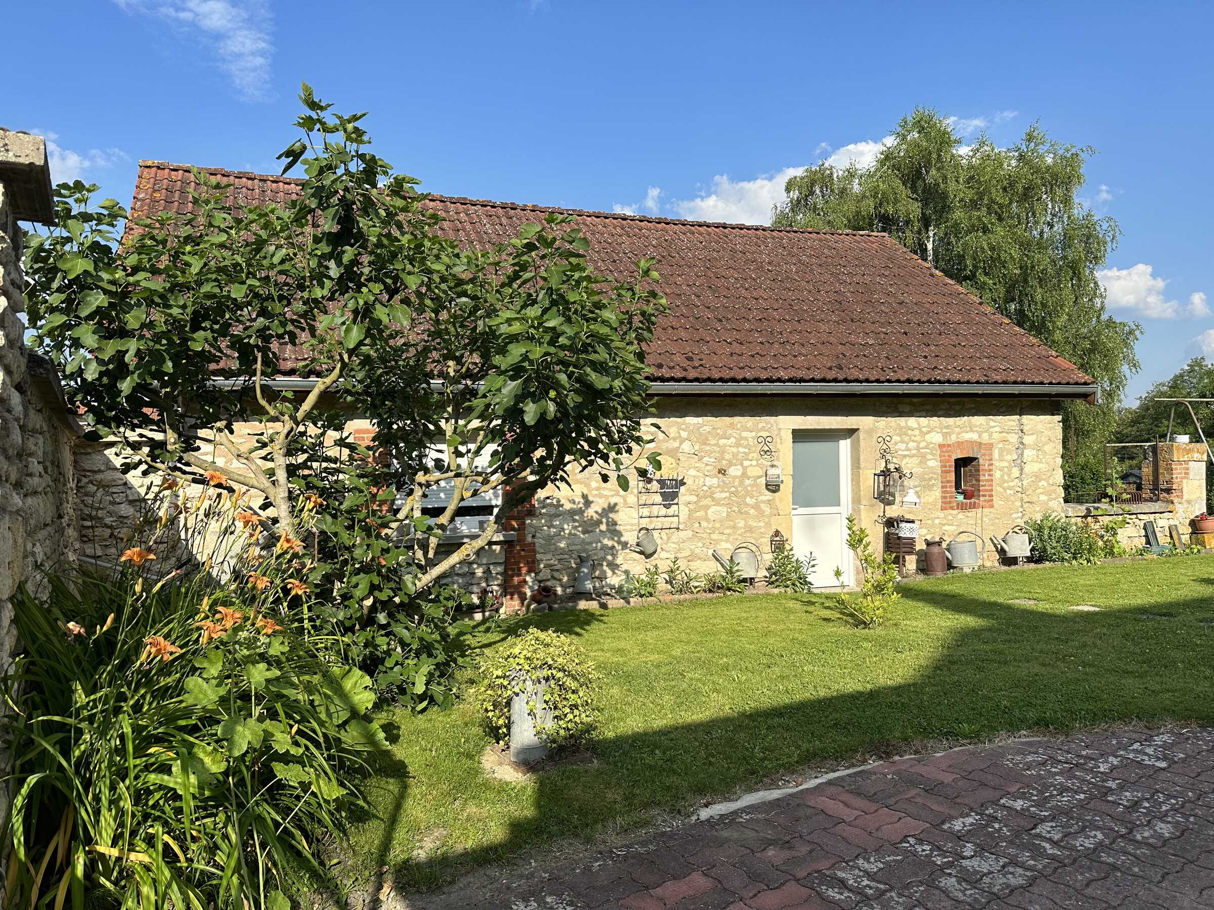 La maison en pierre du gîte de Poilly et son jardin fleuri, sous le soleil de Champagne